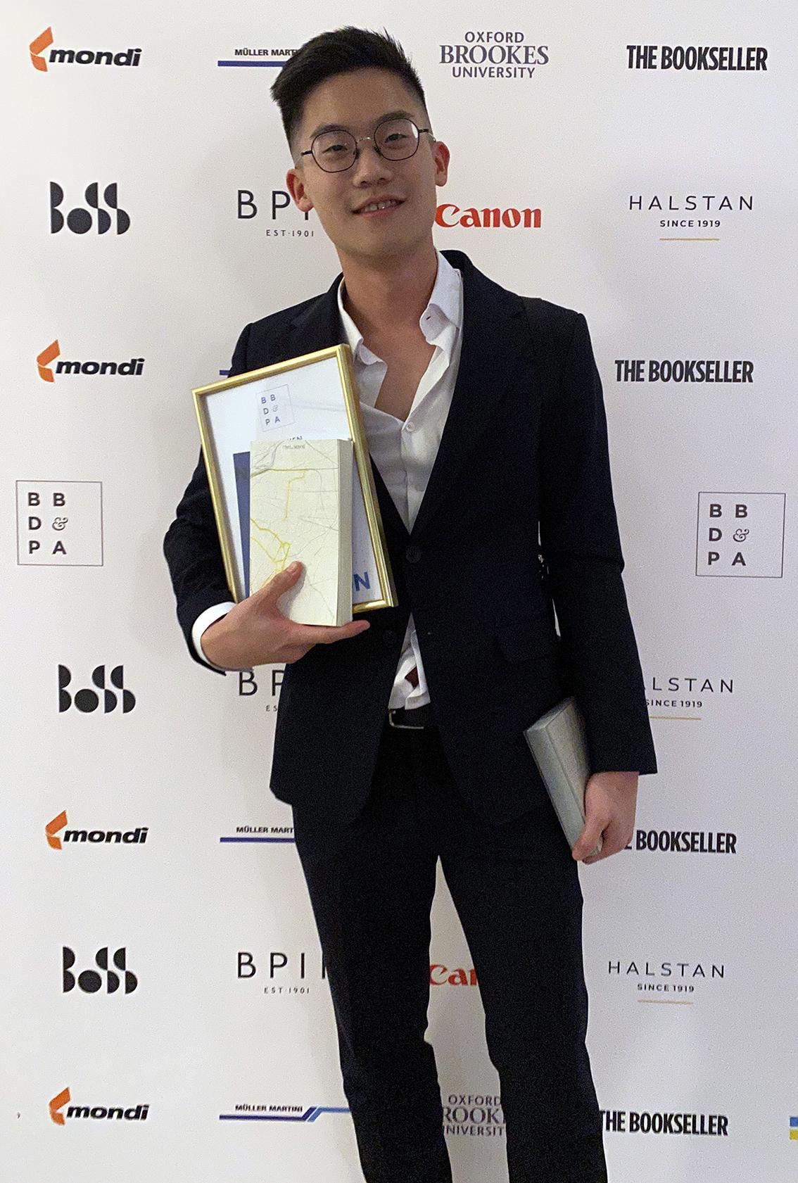 Wen with his book and certificate at the awards event.