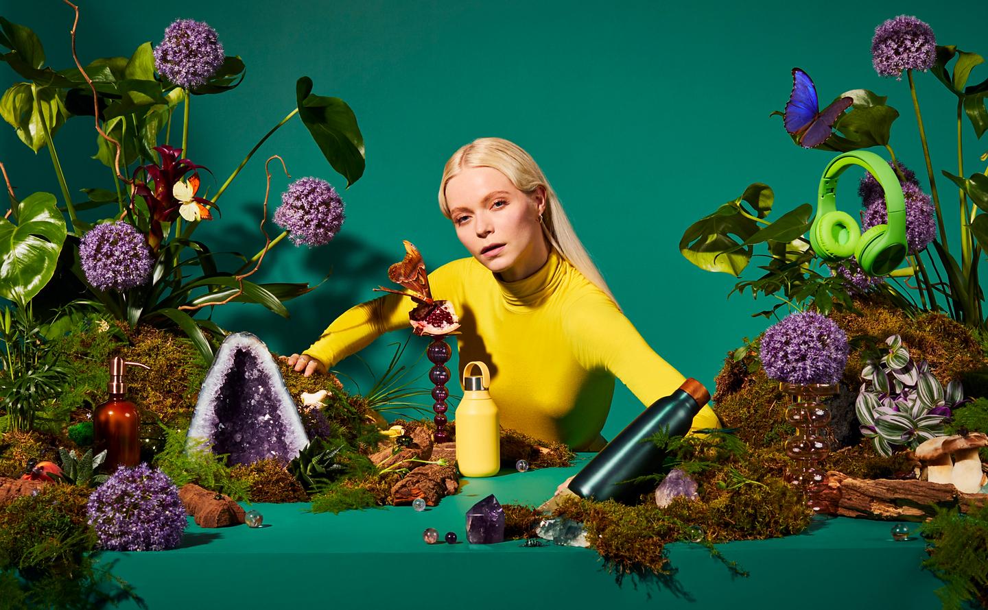 Photograph of a model with a staged scenario of plants and water bottles