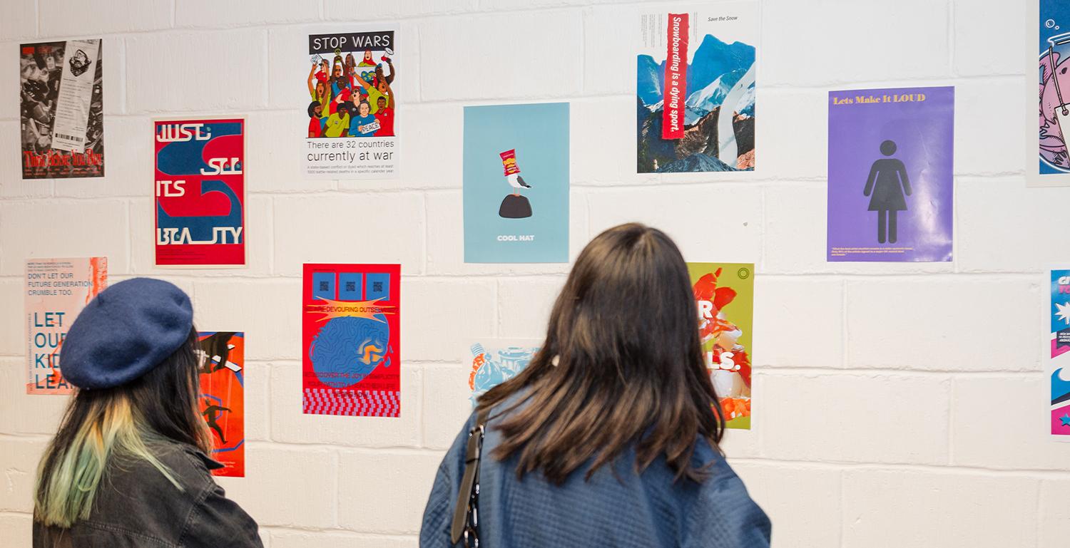 Visitors looking at posters on the wall