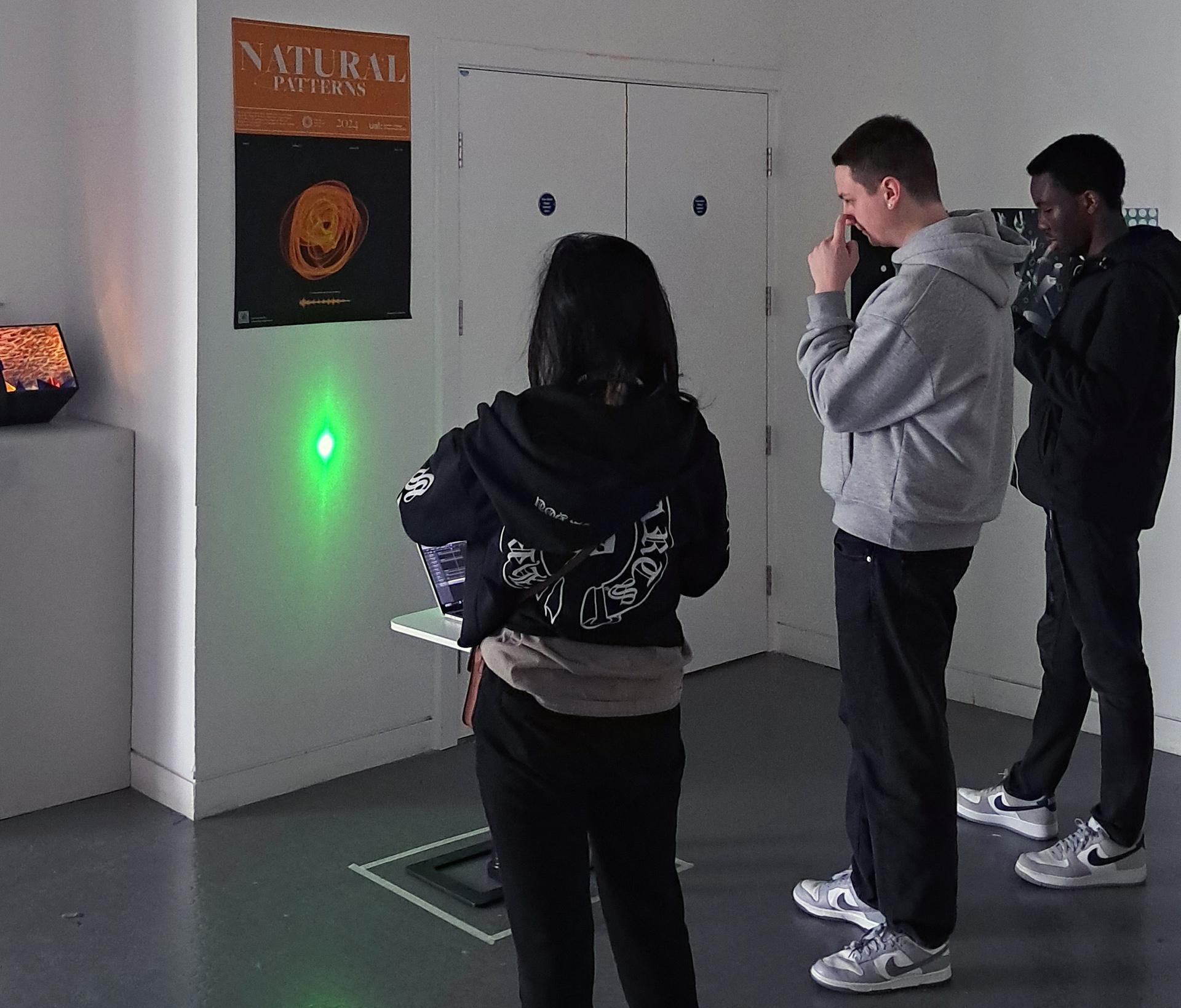 Exhibition view showing students looking at interactive installation.