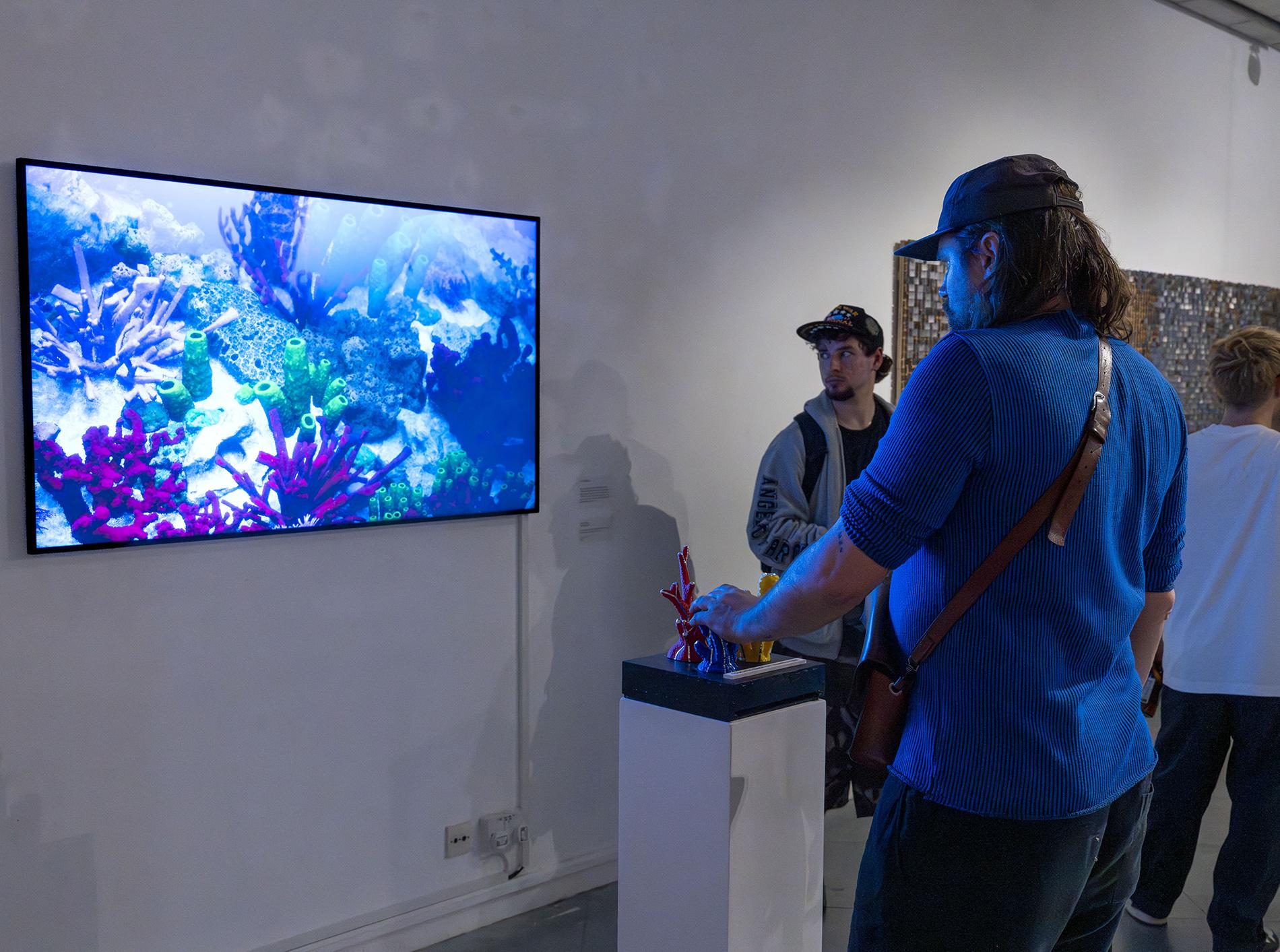 Exhibition visitor using the coral interface and viewing on a large screen.