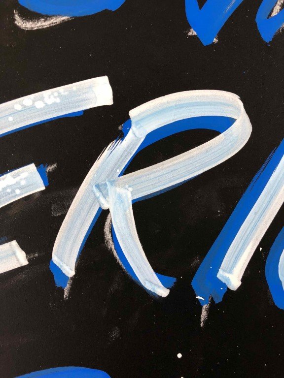 Detailed view of a letter R is white and blue Posca pen, drawn in a brush-like style